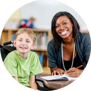 woman writing in notebook beside boy in wheelchair